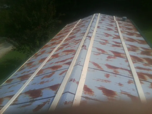 Rusted metal roof panels with new wood purlins before replacement — Storm Damage Roof Repair in Gridley by Roofing Brothers